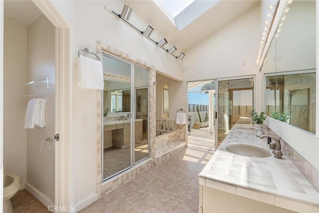 7335 Vista Del Mar Ln, Playa Del Rey, CA 90293 - bathroom featuring double vanity, a skylight, high vaulted ceiling, a bidet, and a tub to relax in