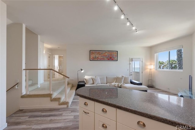 7335 Vista Del Mar Ln, Playa Del Rey, CA 90293 - kitchen featuring light wood-style flooring, white cabinetry, dark stone countertops, track lighting, and open floor plan