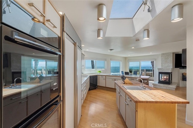 7335 Vista Del Mar Ln, Playa Del Rey, CA 90293 - kitchen with butcher block countertops, a sink, black appliances, and light wood-style floors