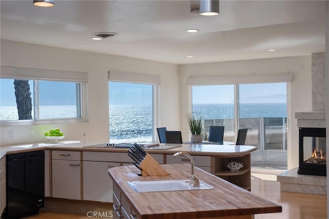 7335 Vista Del Mar Ln, Playa Del Rey, CA 90293 - kitchen with a sink, black dishwasher, cooktop, butcher block countertops, and a center island with sink