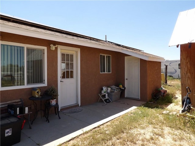 back of house featuring stucco siding and a patio