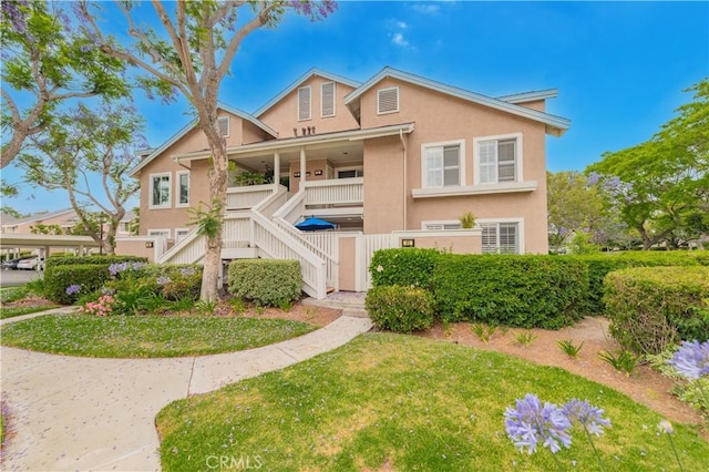 61 Greenfield Unit 68, Irvine, CA 92614 - view of property with stucco siding, stairway, a front yard, and a porch