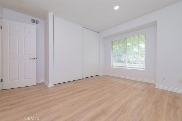 61 Greenfield Unit 68, Irvine, CA 92614 - unfurnished bedroom featuring light wood finished floors, baseboards, recessed lighting, and a closet