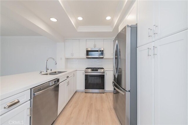 61 Greenfield Unit 68, Irvine, CA 92614 - kitchen with appliances with stainless steel finishes, a sink, white cabinets, light wood finished floors, and recessed lighting