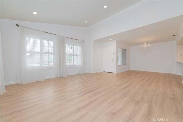 61 Greenfield Unit 68, Irvine, CA 92614 - unfurnished living room with a chandelier, crown molding, light wood finished floors, recessed lighting, and baseboards