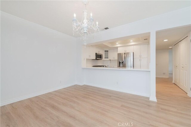 61 Greenfield Unit 68, Irvine, CA 92614 - unfurnished living room with a chandelier, crown molding, recessed lighting, light wood finished floors, and baseboards