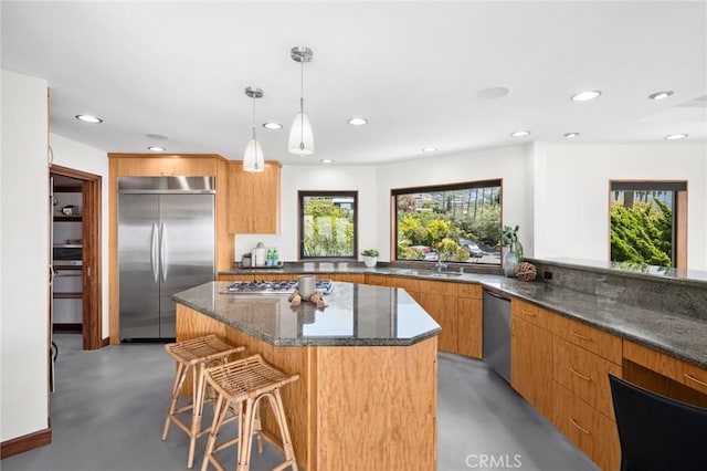 31532 Valido Rd, Laguna Beach, CA 92651 - kitchen featuring appliances with stainless steel finishes, finished concrete flooring, dark stone countertops, a breakfast bar, and recessed lighting