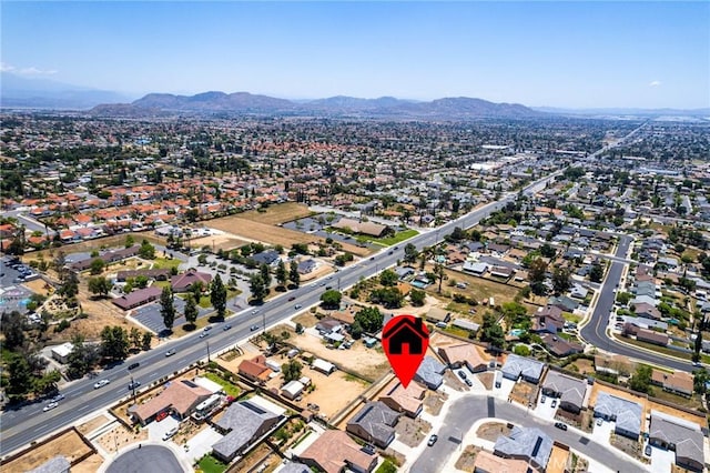aerial overview of property's location with a mountainous background and nearby suburban area