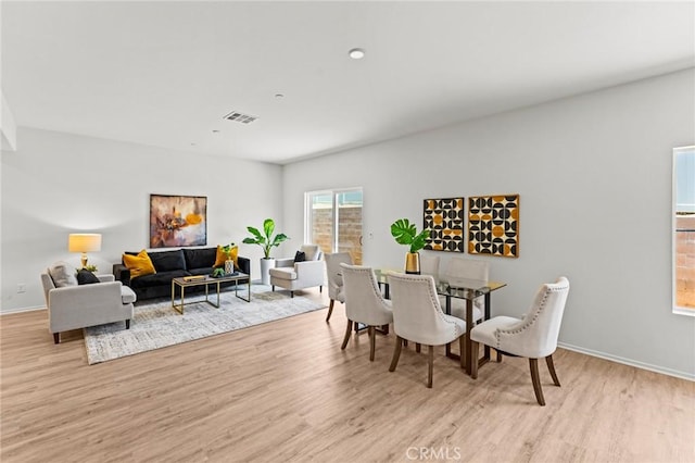 dining space with light wood-style floors and baseboards