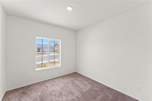 carpeted empty room with baseboards and recessed lighting