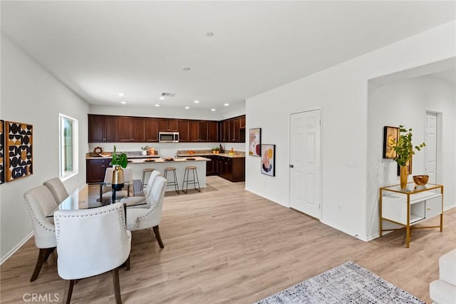 dining area with light wood-style floors, recessed lighting, and baseboards