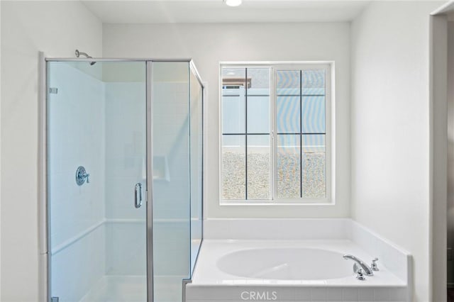 bathroom with a stall shower, a bath, and plenty of natural light