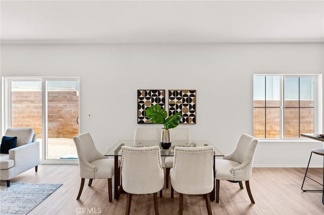dining room with light wood-type flooring and baseboards