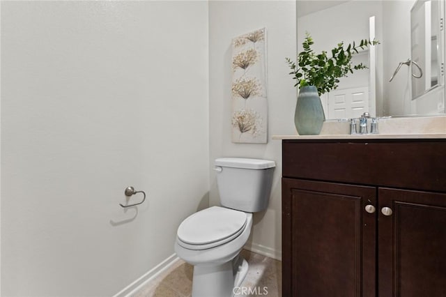 bathroom featuring baseboards, toilet, and vanity