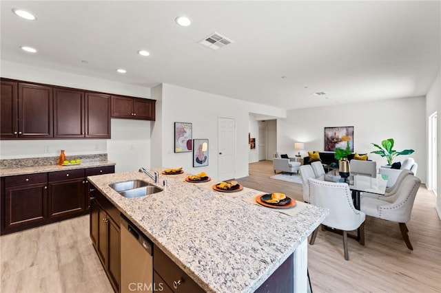 kitchen featuring a sink, stainless steel dishwasher, light wood-type flooring, an island with sink, and recessed lighting