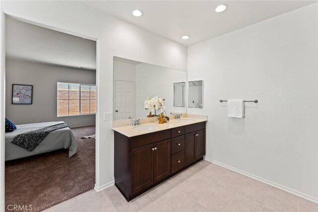full bath featuring baseboards, recessed lighting, double vanity, and ensuite bathroom