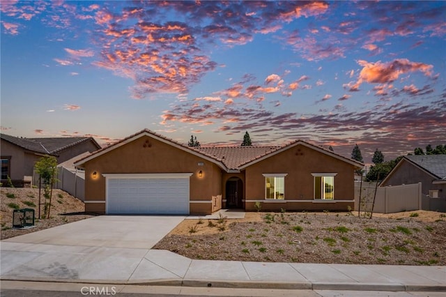 ranch-style house featuring an attached garage, stucco siding, concrete driveway, and a tile roof
