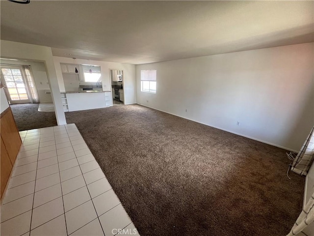 23029 Gray Fox Dr, Canyon Lake, CA 92587 - unfurnished living room featuring light carpet, healthy amount of natural light, baseboards, and light tile patterned floors