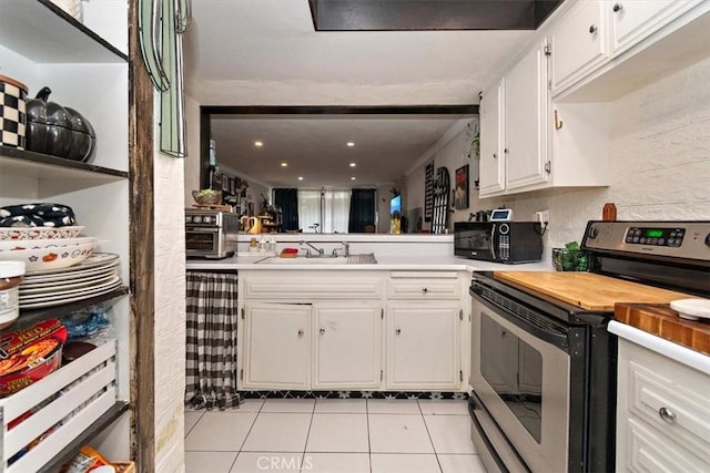 12113 Beverly Blvd Unit A, Whittier, CA 90601 - kitchen featuring stainless steel electric stove, black microwave, a sink, light tile patterned floors, and white cabinetry
