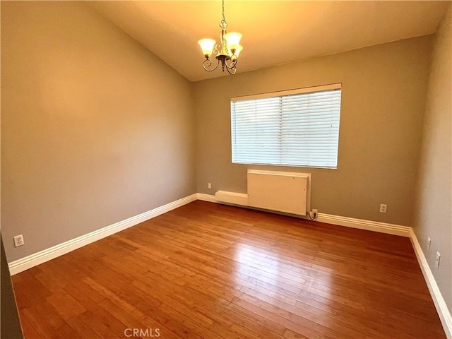 15000 Downey Ave Unit 204, Paramount, CA 90723 - unfurnished room with a chandelier, wood finished floors, baseboards, and vaulted ceiling