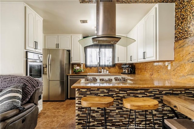 19264 Casmalia St, Rialto, CA 92377 - kitchen with stainless steel appliances, island exhaust hood, white cabinets, and backsplash