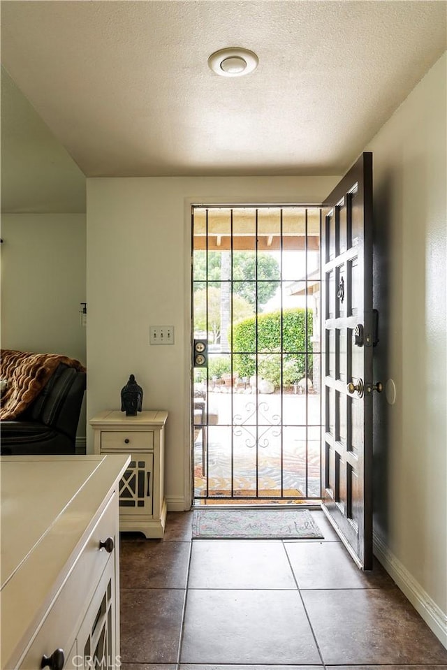 19264 Casmalia St, Rialto, CA 92377 - doorway with baseboards and a textured ceiling