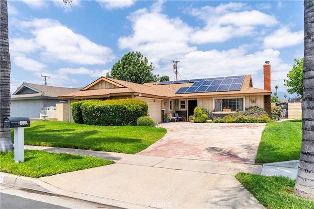 19264 Casmalia St, Rialto, CA 92377 - single story home featuring a garage, driveway, a chimney, a front yard, and roof mounted solar panels