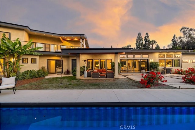 1088 Via Conca Doro, Vista, CA 92084 - back of property at dusk with an outdoor living space, a patio, an outdoor pool, and stucco siding