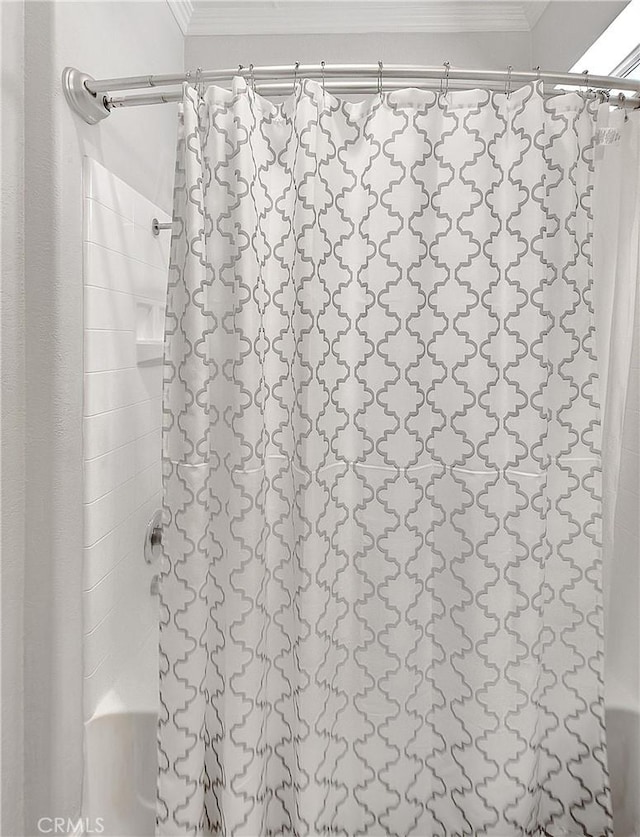 full bathroom with ornamental molding and shower / tub combo with curtain