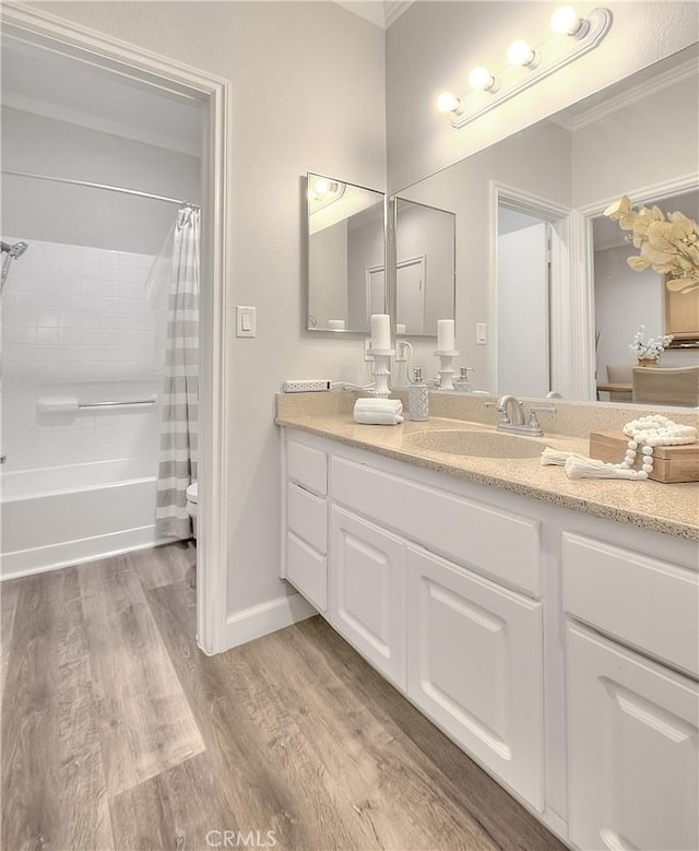 full bathroom featuring crown molding, toilet, wood finished floors, vanity, and shower / bathtub combination with curtain