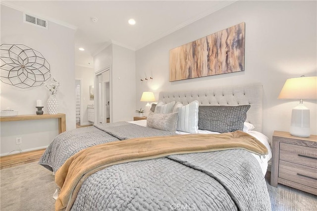 bedroom featuring wood finished floors, crown molding, recessed lighting, and ensuite bathroom