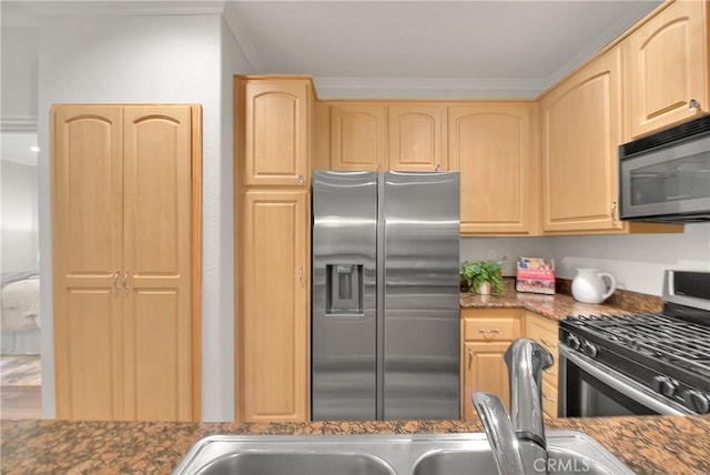 kitchen featuring stainless steel appliances, light brown cabinets, dark stone counters, and ornamental molding