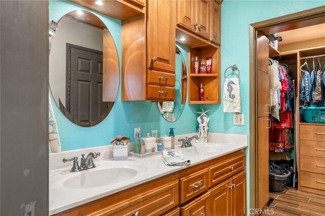 330 E Gladstone St, San Dimas, CA 91773 - bathroom featuring double vanity, wood finished floors, and a spacious closet
