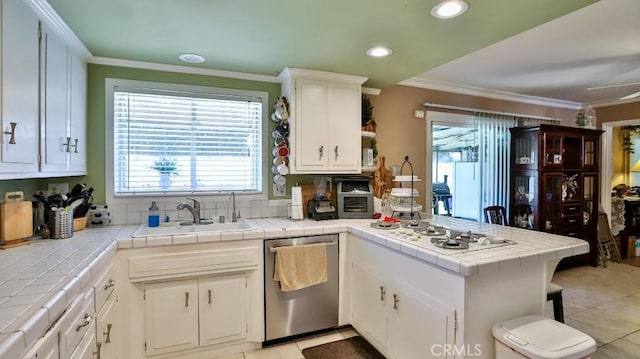 kitchen featuring a sink, a peninsula, dishwasher, tile countertops, and crown molding
