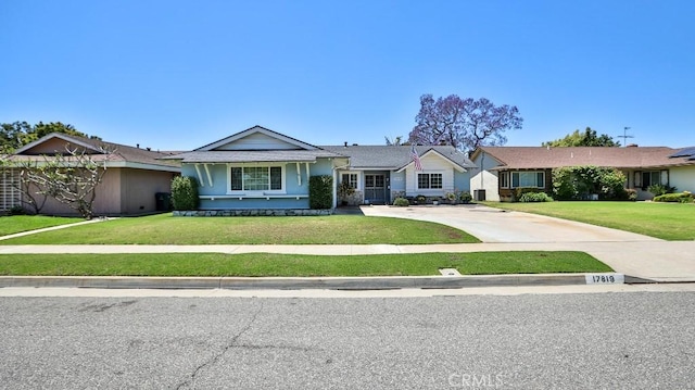 single story home featuring a front yard and concrete driveway