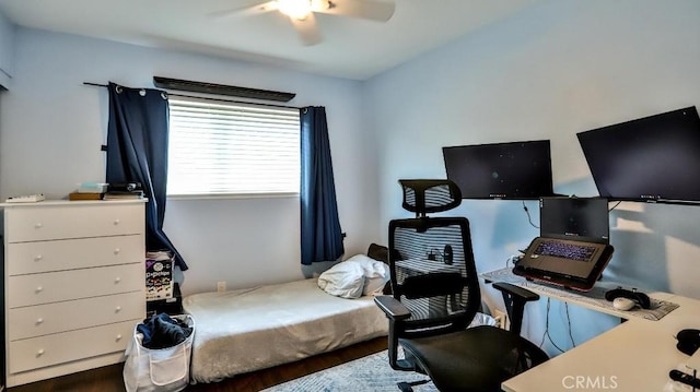 bedroom featuring wood finished floors, an office area, and ceiling fan