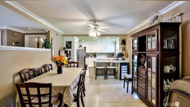 dining room with ceiling fan, ornamental molding, and light tile patterned flooring
