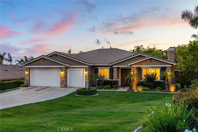 view of front facade featuring a garage, concrete driveway, stone siding, a front yard, and stucco siding
