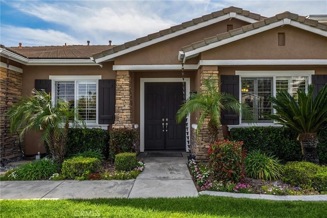 entrance to property featuring stucco siding and stone siding