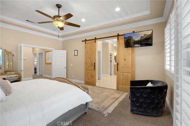 bedroom featuring a barn door, crown molding, multiple windows, and a raised ceiling