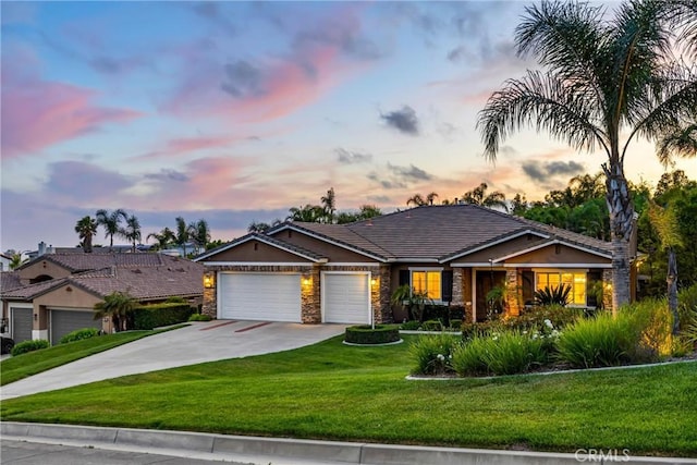 single story home featuring an attached garage, concrete driveway, a front yard, stone siding, and stucco siding