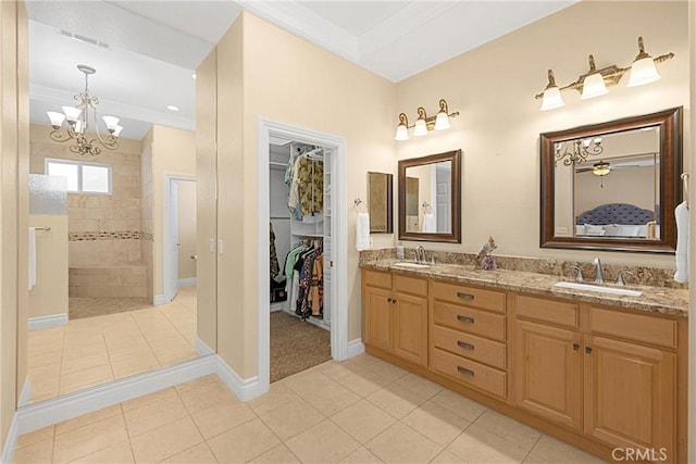 full bathroom with a chandelier, a walk in shower, tile patterned flooring, double vanity, and baseboards