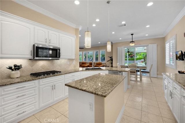 kitchen featuring stainless steel appliances, a peninsula, a kitchen island, recessed lighting, and decorative backsplash