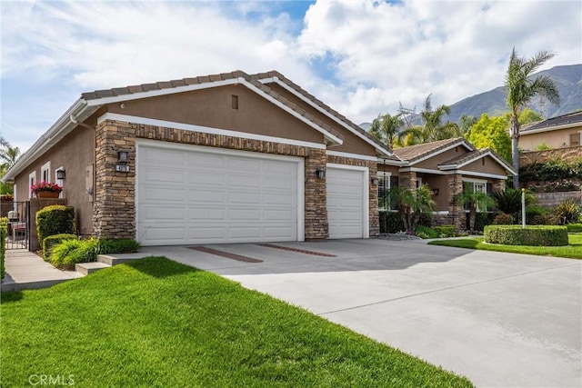 view of front of home featuring stone siding, stucco siding, concrete driveway, an attached garage, and a mountain view