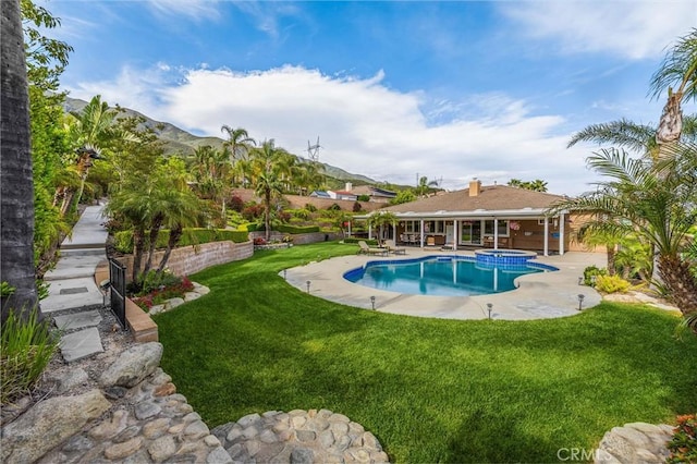 view of swimming pool with a yard, a patio area, and a pool with connected hot tub