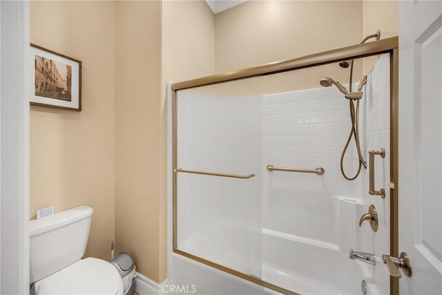full bathroom featuring toilet and bath / shower combo with glass door