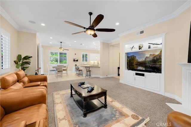 carpeted living room featuring a ceiling fan, recessed lighting, ornamental molding, and baseboards