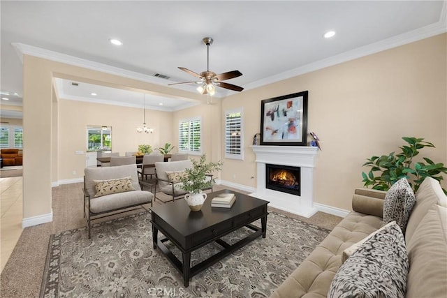 carpeted living area featuring baseboards, a ceiling fan, a warm lit fireplace, recessed lighting, and crown molding