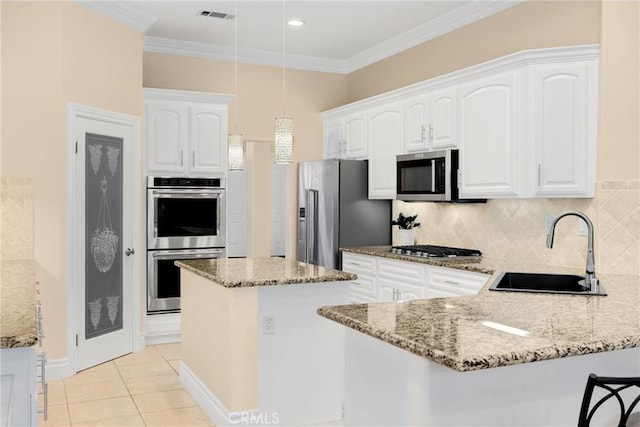kitchen featuring stainless steel appliances, a sink, a peninsula, light stone counters, and crown molding