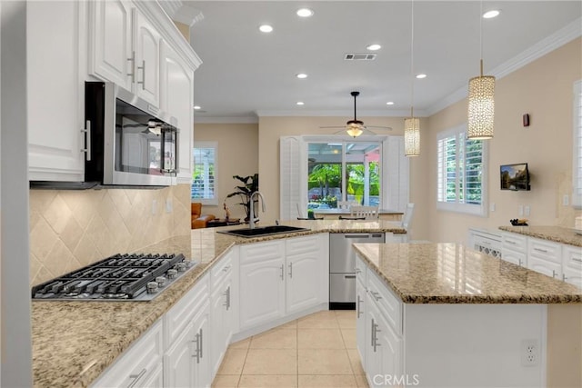 kitchen featuring stainless steel appliances, a sink, a peninsula, decorative backsplash, and recessed lighting